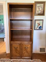Full view of wood bookcase showing shelves and cabinet doors