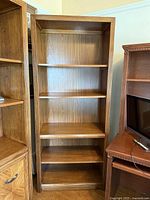 Front view of tall wood bookcase with five tiers
