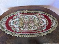 Full view of oval floral table runner on wooden surface