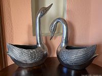 Front view of both silver swan planters showing overall form and etched feather detail