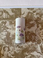 Front view of white cylindrical porcelain wall vase with purple floral design