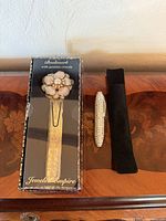 Boxed Jeweled Empire bookmark, rhinestone pen, black pouch on wood surface