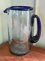 Full view of glass pitcher showing shape, rim, handle