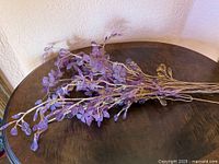 Full view of lilac crystal glass faux flower spray on table
