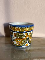 Front view of ceramic planter showing hand-painted motifs