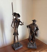 Front view of both paper mache figures on wooden surface