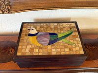 Top view of wooden jewelry box displaying bird mosaic lid and artist signature