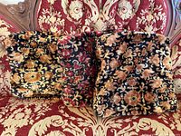 Three tapestry cushion covers displayed on chair