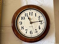 Front view of Timex wooden wall clock showing dial and wood case