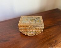 Westland Art of Chokin music box resting on brocade doily, lid floral insert visible
