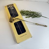 Box containing four navy tapers and brass snuffer