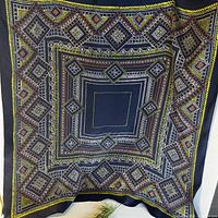 Full view of square navy silk scarf showing complete geometric pattern