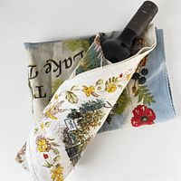 Tea towel wrapped around wine bottle showing print and fabric