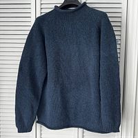 Rear view of dark navy wool sweater on hanger