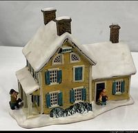 Front and side view of porcelain house showing shutters, porch, chimneys and figures