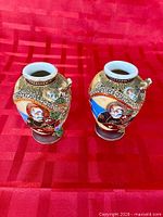 Pair of vases front view showing portraits and dragon relief