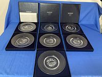 Seven etched crystal plates in presentation cases with letter