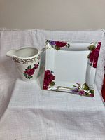 Pitcher and square dish side by side on white cloth