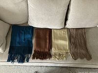 All four scarves laid out on sofa