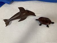 Dolphin figurine and closed turtle box side by side