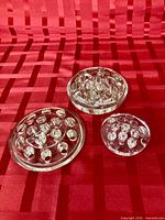 All three clear glass flower frogs on red background