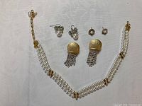Full set showing necklace and three earring pairs on white background