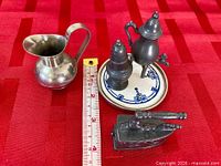 All six miniature items grouped on red surface beside ruler showing scale