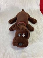 Front view of dark brown Pound Puppies plush dog showing face, body and red collar.