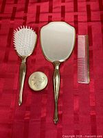 Front view of mirror, brush, comb and jar