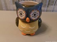 Front view of multicolor ceramic owl container