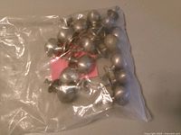 Bag containing multiple brushed silver drawer pulls