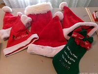 Group view of five Santa hats and two stockings