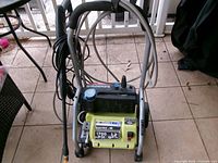 Front view of pressure washer showing frame, hose, spray wand, power cord