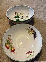 Two stoneware bowls with floral and fruit designs