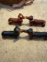 All four ceramic dachshund shakers on carpet