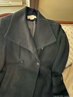 Front view of black wool double-breasted coat