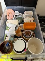 Overview of plastic bin containing assorted planters and ornaments