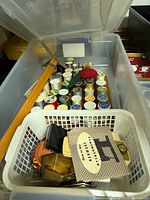 Clear tote containing rows of thread spools, basket with Kenmore booklet and attachments