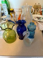 Group shot of six glass vases and frosted swan figurine