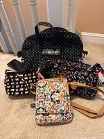 Four Vera Bradley bags displayed together showing patterns and sizes