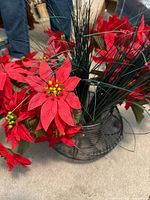 Overall view of wire container with faux poinsettias and grass stems