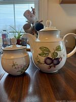 Teapot and sugar bowl front view showing fruit and floral designs