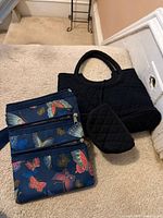 Handbag, pouch and crossbody grouped on carpet