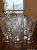 Group of eight tall etched footed glasses