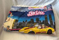 Folded Barbie woven throw showing main graphic and fringe