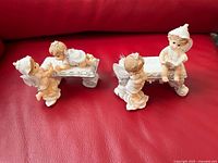 All four figurines positioned on two benches