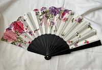 Fan fully opened showing floral print and black ribs