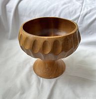 Side view of carved wooden pedestal bowl