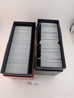 Two boxes filled with stacked Pokémon cards