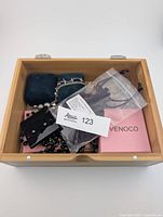 Wooden box holding jewelry boxes, pouch and beaded strand